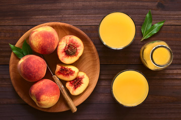 Pfirsichsaft in Gläser, mit frischen Pfirsichen an der Seite, fotografiert mit natürlichem Licht