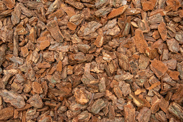 Brown decorative sawdust or pieces of oak bark, top view.  Background Texture