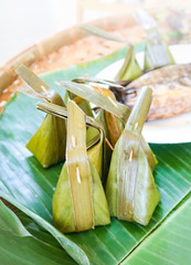 Steamed flour with coconut filling on banana leaf