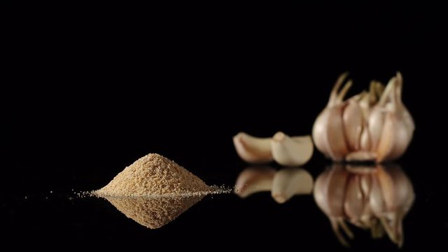STOP MOTION: Garlic powder appearing near to garlic cloves