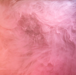 Pink paint dissolving into liquid, acrylic abstraction. Close up view. Blurred background. Acrylic ink mixing with liquid, abstract background. Pink clouds swirling in water, abstract pattern