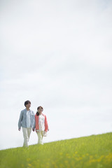 草原を歩くカップル