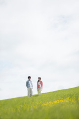 草原を歩くカップル