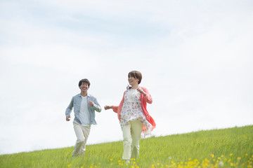 Fototapeta premium 草原を走るカップル