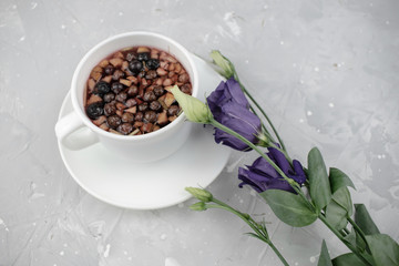 Mixture herbal floral tea with petals, dry berries and fruits. healthy drink. Hot fruit, healthy tea in a white mug