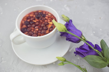 Mixture herbal floral tea with petals, dry berries and fruits. healthy drink. Hot fruit, healthy tea in a white mug