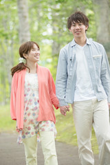 Fototapeta premium 新緑の中で散歩をするカップル