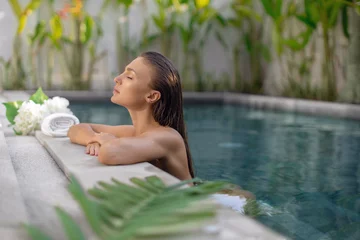 Raamstickers Young beautiful girl relaxes in the pool during spa procedures © fotoplaton
