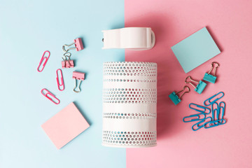 School and office stationery on pink and blue background, top view