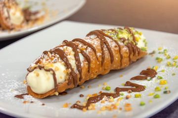 Cannoli italian cake with pistachios and chocolate, close up.