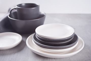 Empty black and white plates over gray table.