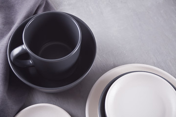 Empty black and white plates over gray table.