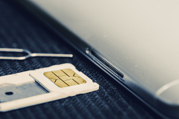 Open Tray of Micro Sim Card Beside Smartphone. Concept of Change or Swapping To New Sim Card