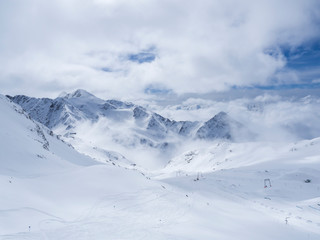 Fototapeta na wymiar Winter landscape with snow covered mountain slopes and empty pistes, spring sunny day at ski resort Stubai Gletscher, Stubaital, Tyrol, Austrian Alps.