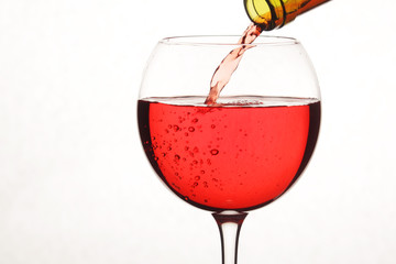 Bright red cocktail pouring to a glass from a bottle