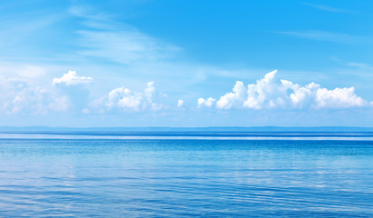 Natural background of blue water surface with reflection of clouds. Lake Baikal on a sunny summer day. Beautiful water landscape