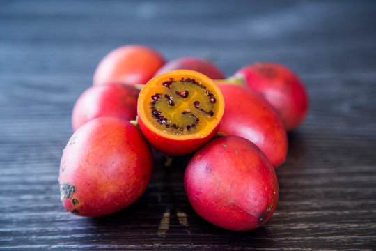 Homegrown, organic tamarillos or tree tomatoes picked from home orchard. Autumn fruit packed with vitamin c to strengthen immune system to prepare for winter. Shown isolated on a dark background.