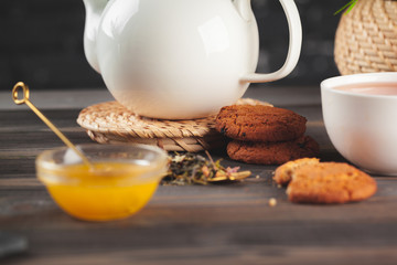 glass teapot with cup of black tea on wooden table