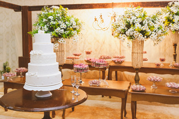 Scenic wedding cake with table bottom decorated with Brazilian flowers and sweets.