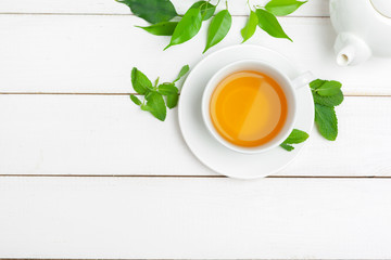 teapot and cups of tea on a white wooden background