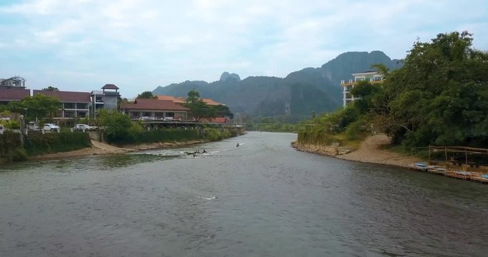 following river flow and boats coming towards in Vang Vieng, Laos, cloudy weather