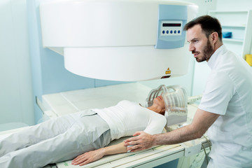 Radiologist preparing patient who is about to receive MRI scan in the hospital.