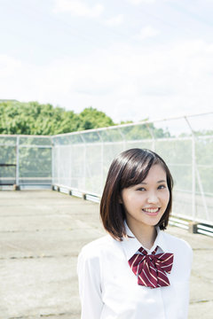 屋上に立つ笑顔の女子高校生