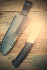 shiny hunting knife and leather scabbard