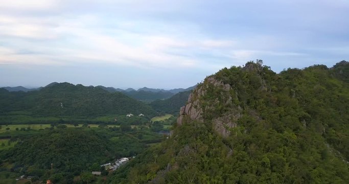 flying around tall mountain in Khao Yai national park, Thailand, clody sky but green forest around