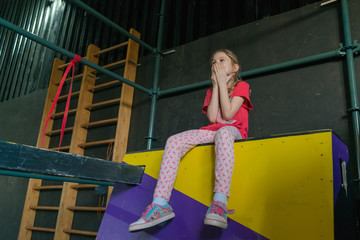 sporty girl rock climber on the climbing wall and trampoline