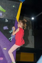 sporty girl rock climber on the climbing wall and trampoline