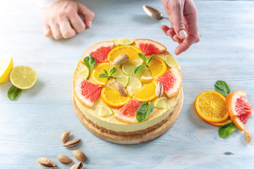 Raw citrus cake with grapefruit, orange, lime and lemon with nuts and mint. Healthy fresh summer dessert