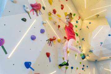 sporty girl rock climber on the climbing wall and trampoline