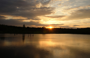 Obraz premium Bright sunset on a forest lake. Silence in the evening.