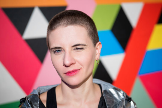 Close-up portrait of young emotional woman with short hair on bright geometric background