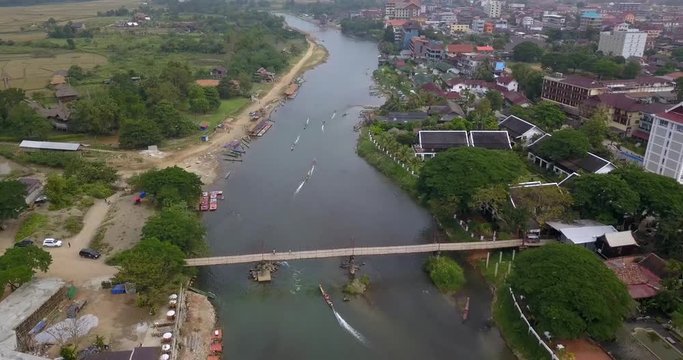 following kayaks in a river above the city Vang Vieng, Laos getting down and closer by drone