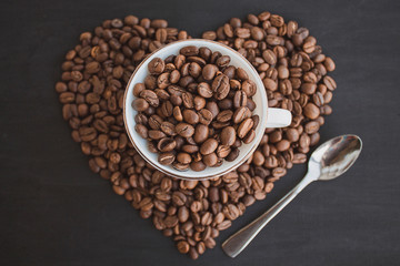 A cup with coffee beans. White tea pair with coffee beans. Heart of coffee.