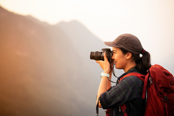 Backpacker woman take photo on peak mountain