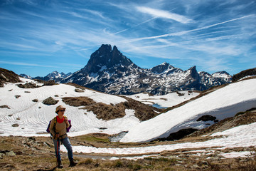 Fototapeta premium hiker woman walking in the french Pyrenees mountains, Pic du midi d Ossau in background