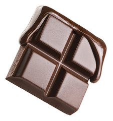 Melted chocolate pours into a piece of chocolate bar isolated on white background.