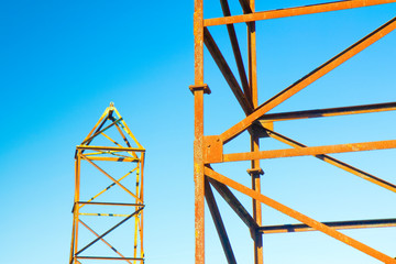 Old rusty iron structure with bolted metal profiles against a blue sky