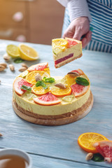 A piece of raw citrus cake with grapefruit, orange, lime and lemon. Healthy fresh summer dessert. Homemade vegan food