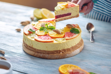 A piece of raw citrus cake with grapefruit, orange, lime and lemon. Healthy fresh summer dessert. Homemade vegan food