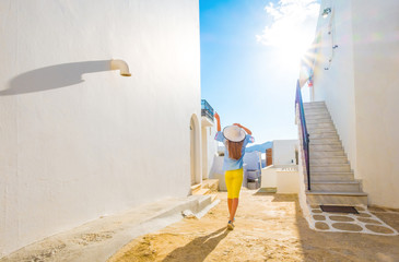 Beautiful little girl in white hat relax on a typical street in Greece