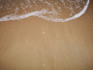 Beautiful splashing swash silky smooth water on the beach during sunny day.