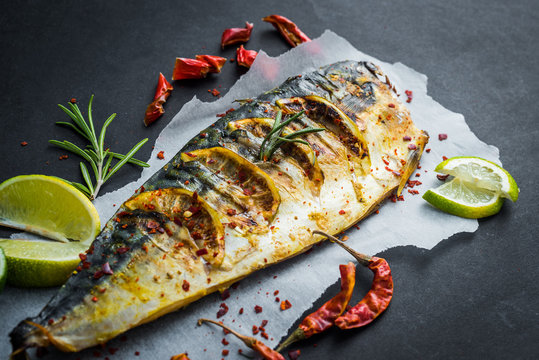 Grilled fish with lime on a black table