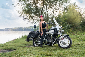 Obraz na płótnie Canvas Beautiful woman posing with helmet and motorcycle