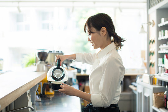 コーヒーを注ぐ20代カフェ店員