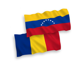 National vector fabric wave flags of Venezuela and Romania isolated on white background. 1 to 2 proportion.