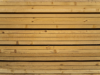 Obraz premium Lots of planks stacked on top of each other in the warehouse. Lumber for further use in construction